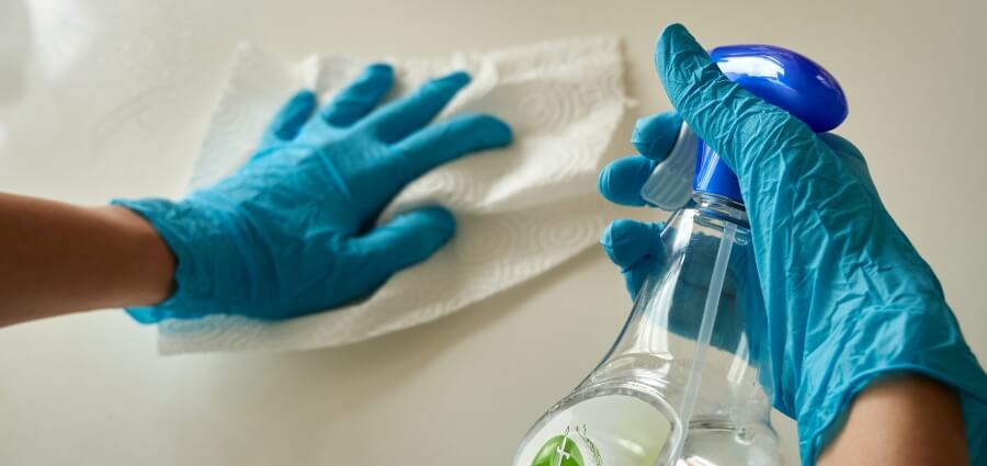 A trained staff cleaning a desktop to disinfect